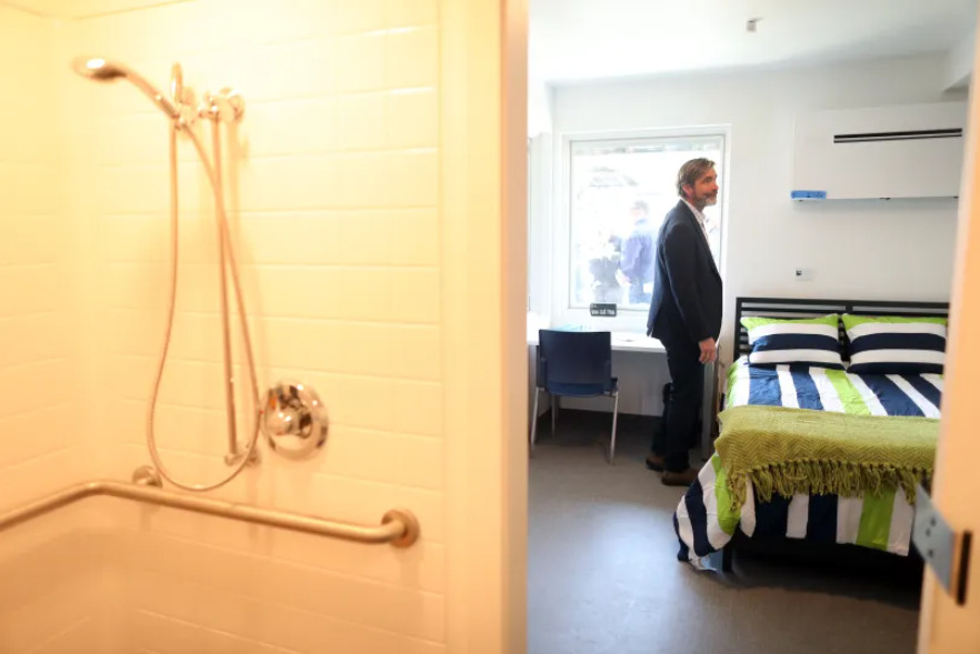 Joe Stockwell tours a housing unit at the San Mateo County Navigation Center on Tuesday, April 18, 2023, in Redwood City, Calif. The $57 million facility has 240 housing units, a dining area, meeting space, laundry, and a dog run. (Aric Crabb/Bay Area News Group) 